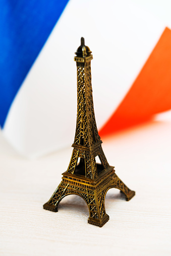 Metal Eiffel Tower and French flag on background