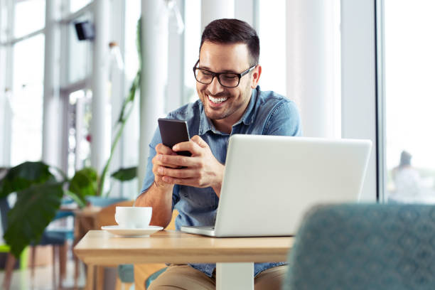 istock Handsome young male smiling and looking at his phone while on lunch break. 1066870986