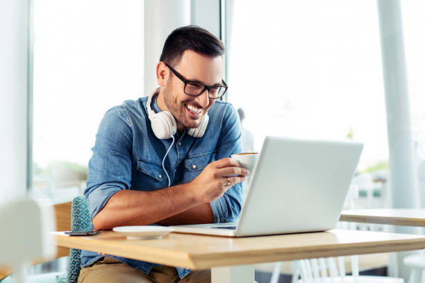 istock Happy handsome man drinking coffee and looking at his laptop. 1066871246