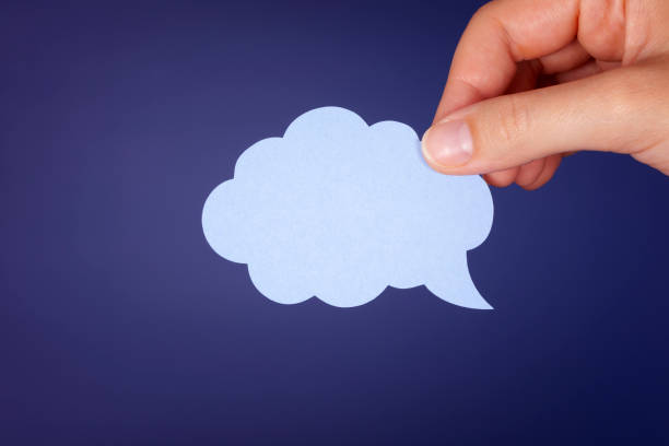 istock Hand holding blue speech bubble over dark blue background 1066879684