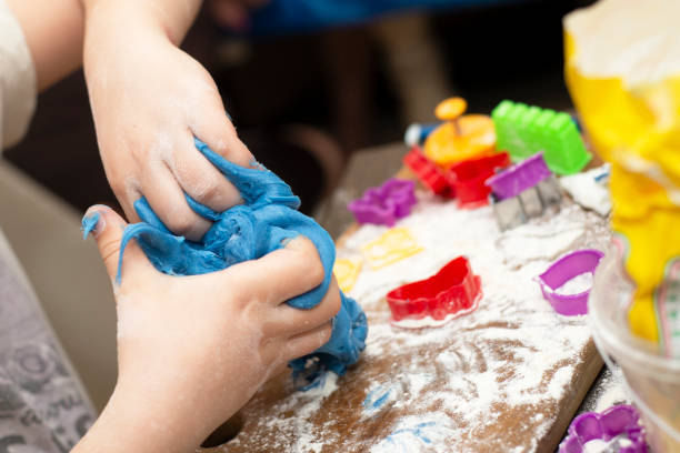 istock Child hands molding a shape with a blue dought 1066882686