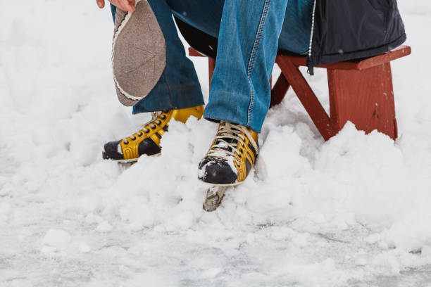 istock man in ice skates sits on wooden bench 1066882968