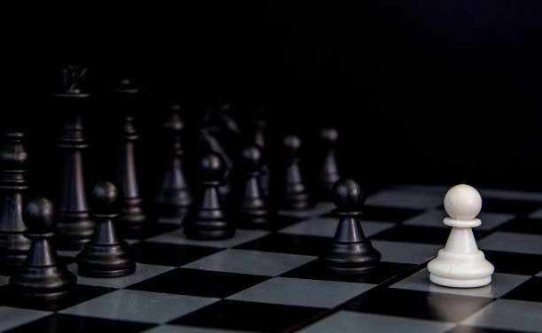 istock Black chess figures on board. Black chess figures row on checkered board. 1066883672