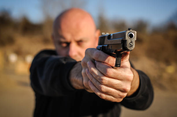 istock Police agent bodyguard gun pointing pistol to attacker. Front view 1066886788