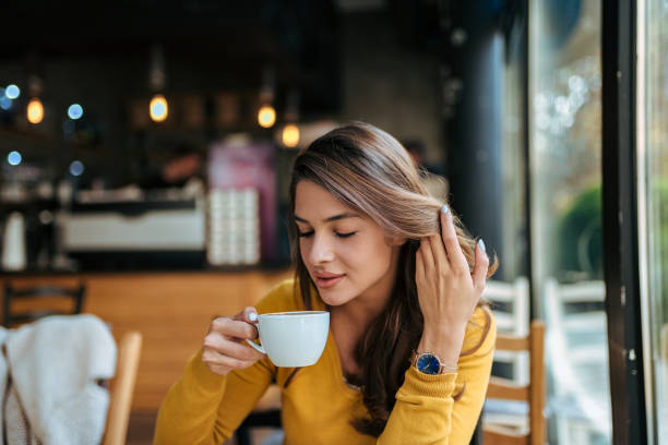 istock Stylish young woman drinking coffee at the cafe. 1066894634