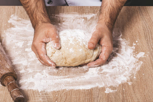 istock male chef kneads the dough 1066895234