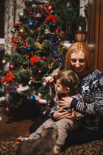 istock Mother and son sitting beside Christmas tree at home 1066896714