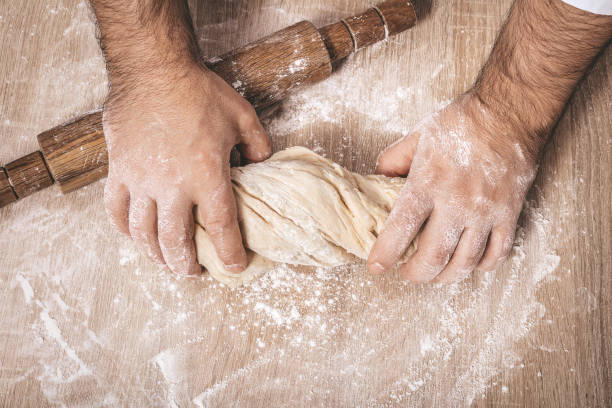 istock male chef kneads the dough 1066897200