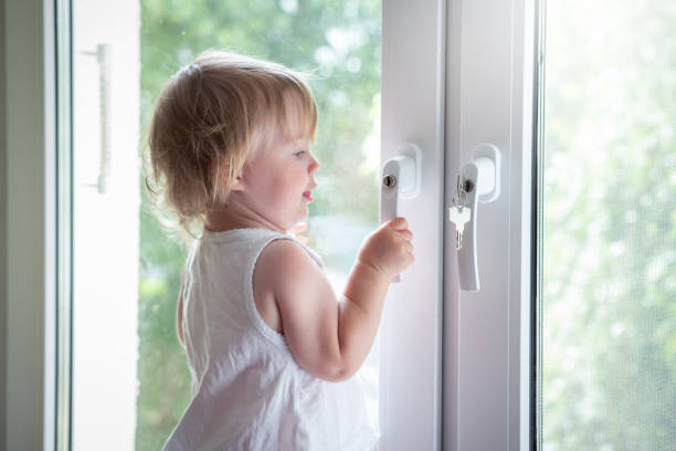 istock Child on window sill on high floor 1066897218