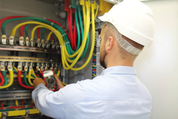 istock Electrician at work measures voltage in industrial distribution fuseboard 1066897376