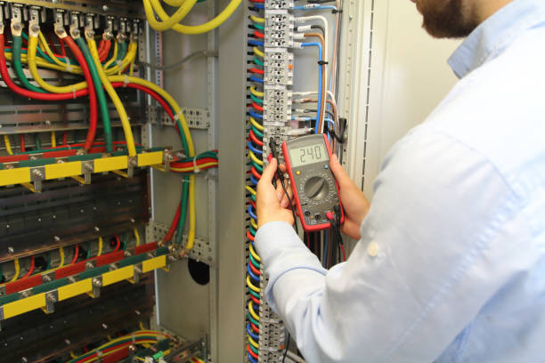 istock Electrician is working in electrical cables distribution fuse box with multimeter 1066897386