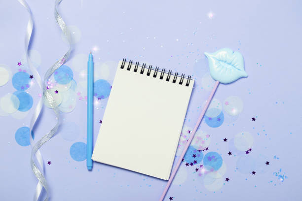 istock Empty note pad on blue frozen festive background with confetti and sparkles. 1066898096