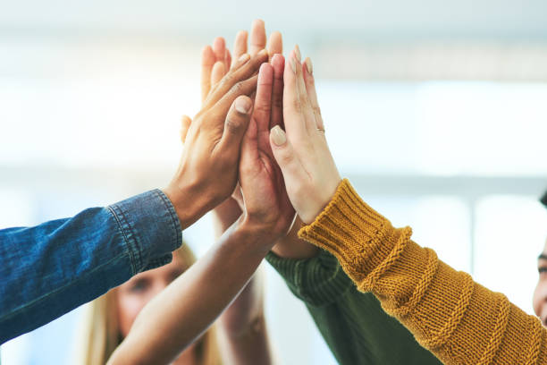 Together, anything is possible Closeup shot of a diverse group of people high fiving together hand palm stock pictures, royalty-free photos & images