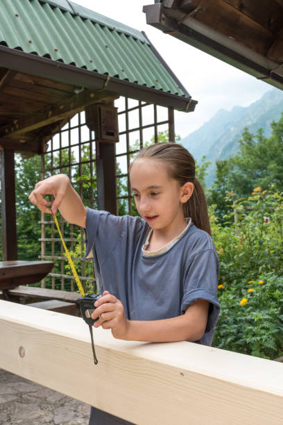 istock Young Girl Measuring Wooden Support Beam 1066901852