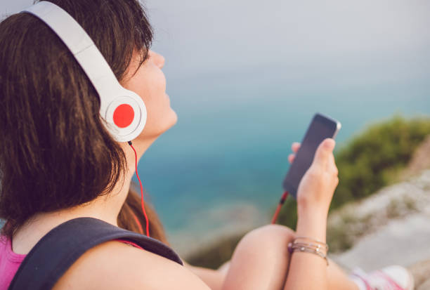 istock Woman using phone at seaside viewpoint 1066908388