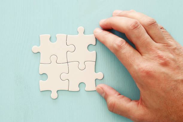 istock male hand and the piece in the puzzle. 1066909324