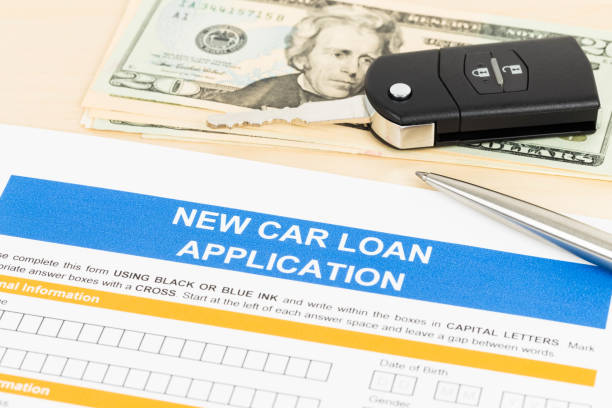 istock Car loan application with car key, pen, and dollar banknote 1066911364