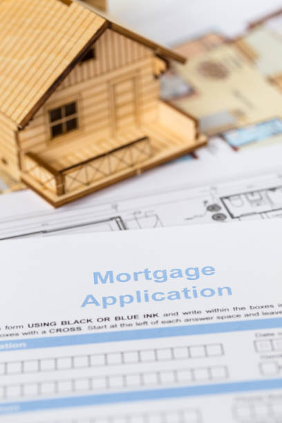 istock House mortgage application with model house and construction plan 1066911678