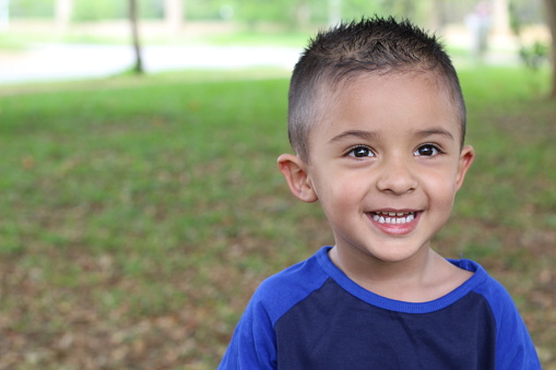 Hispanic child smiling in the park.