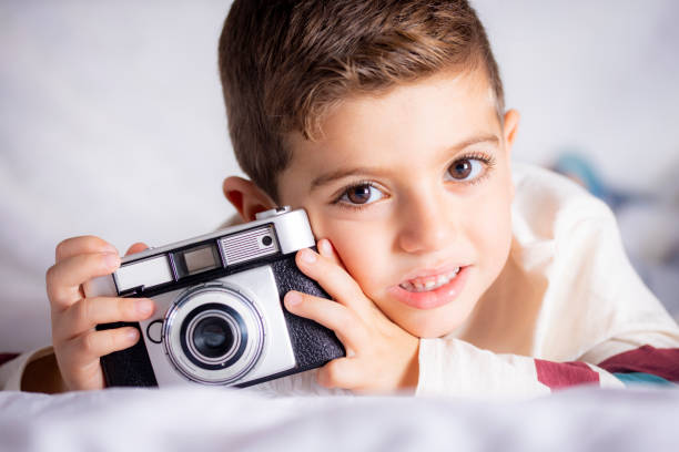 istock Beautiful boy with a photographing camera in the bed 1066917464