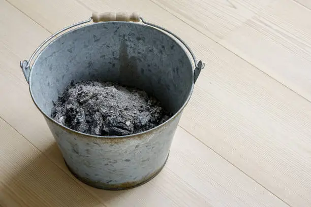 Photo of Ash in a metal bucket.