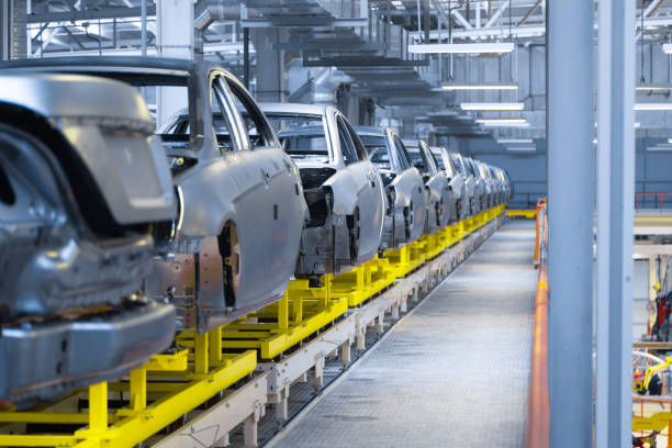 circulación de vehículos a lo largo de la línea de producción en la planta. tienda del montaje del coche. ensamblaje del coche por piezas - fábrica de coches fotografías e imágenes de stock