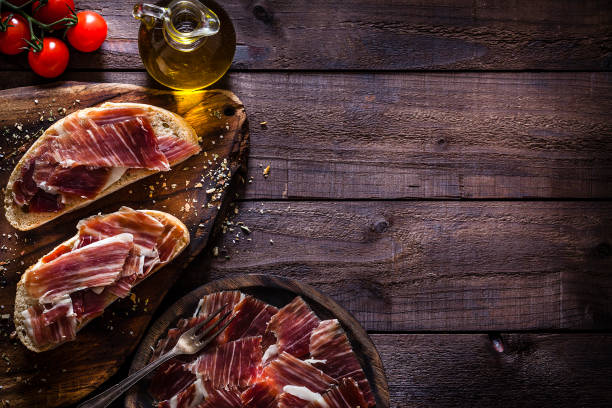 plateau de jambon iberico délicieux tiré sur une table en bois rustique - food appetizer still life ham photos et images de collection