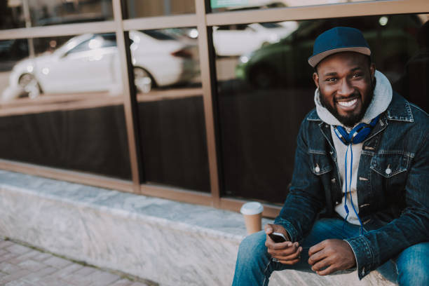 istock Joyful afro american guy sitting in urban settings 1066930178
