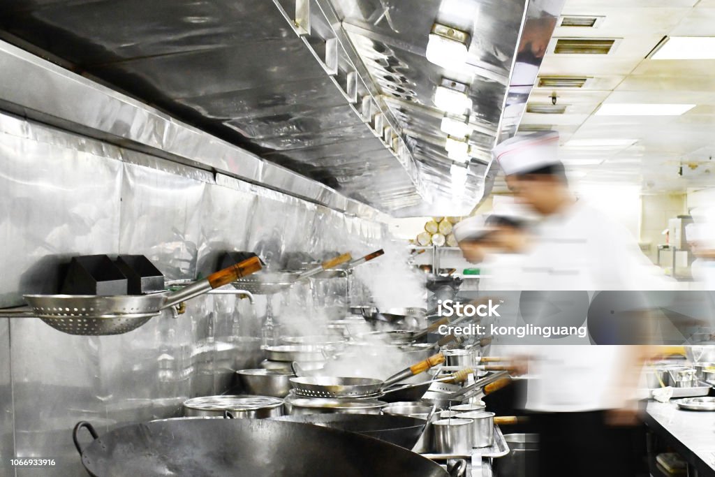 Busy Chinese restaurant kitchen. Busy chefs preparing dishes in Chinese restaurant kitchen. Commercial Kitchen Stock Photo