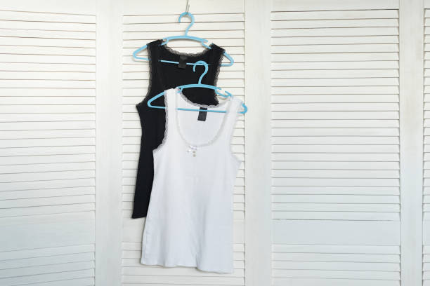 istock White and black jerseys on the hanger. White shutters on the background 1066934328