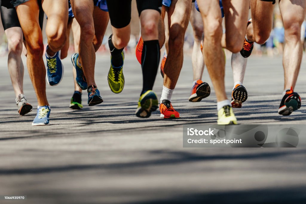 las piernas del grupo corredores hombres corriendo en carretera asfaltada - Foto de stock de Maratón libre de derechos