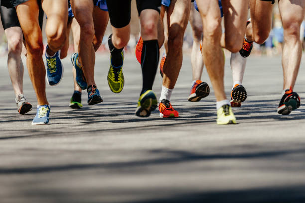 legs group men runners running on asphalt road legs group men runners running on asphalt road kilometer photos stock pictures, royalty-free photos & images