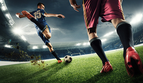 Dos hombres están jugando al fútbol y competir con otros photo