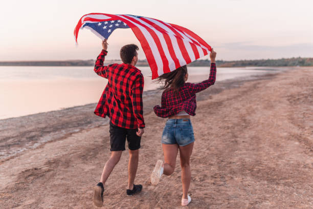 istock oung couple on the beach walking together 1066938496