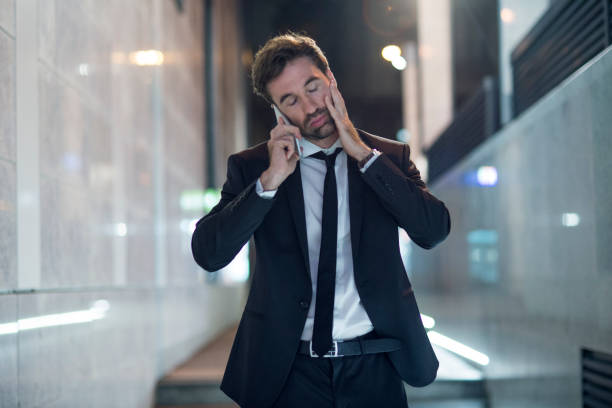 istock businessman using his smartphone in the city at night 1066938560