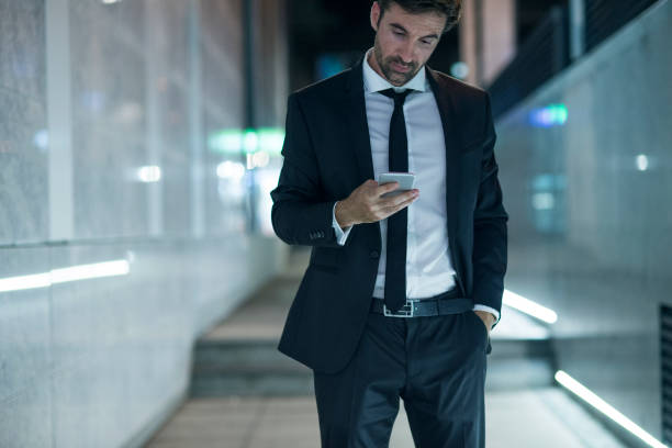 istock businessman using his smartphone in the city at night 1066938786