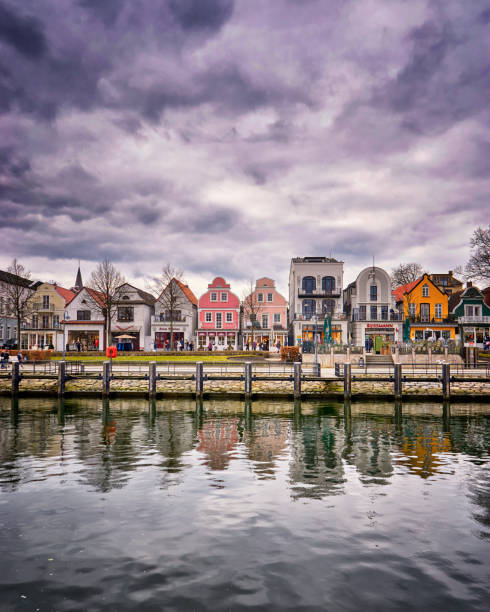 Warnemünde cityscape at the old canal or old stream. The once sleepy fishing village was founded in 1200. Warnemünde cityscape at the old canal or old stream. The once sleepy fishing village was founded in 1200. alte algarve stock pictures, royalty-free photos & images