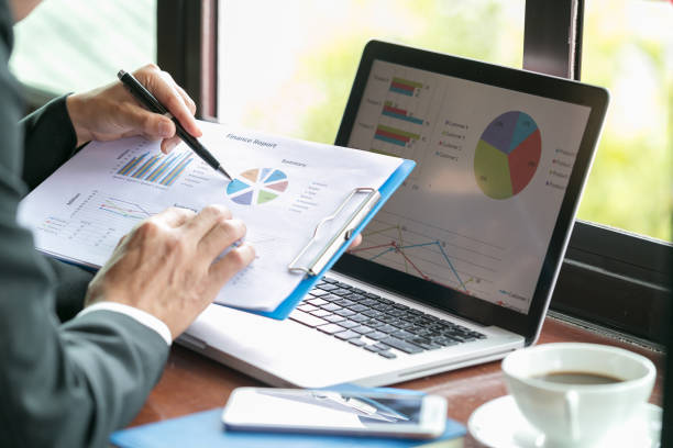 istock Two businessmen analyzing stats financial data on pc laptop, pointing at screen with rising graph and charts, discussing company growth, 1066939732