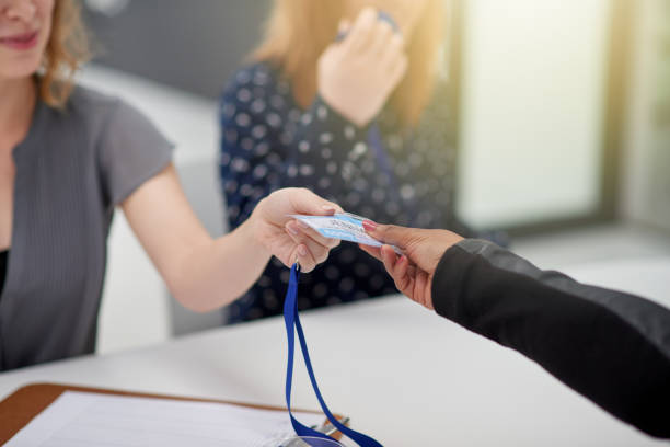Closeup of an unrecognizable businesswoman handing over a access card to a newly signed up client to attend a seminar during the day