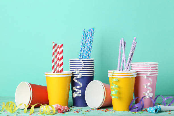 istock Colorful paper cups with straws and confetti on mint background 1066941280