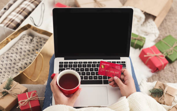 Woman ordering presents on laptop and drinking coffee, copy space Christmas shopping. Woman ordering presents on laptop and drinking coffee, copy space holiday shopping stock pictures, royalty-free photos & images