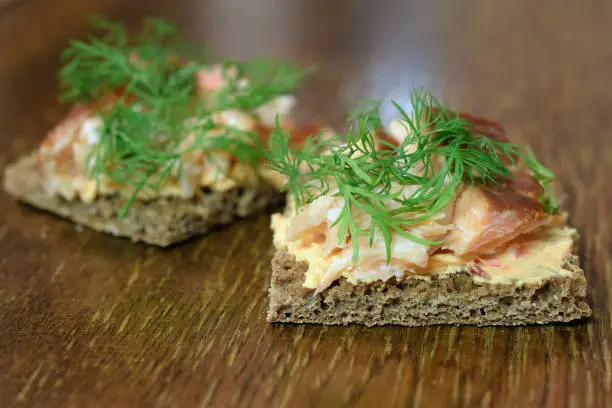 Canapes with smoked Arctic char, paprika cream cheese and dill on rye bread. Delicious starter or cocktail snack. Copy space.