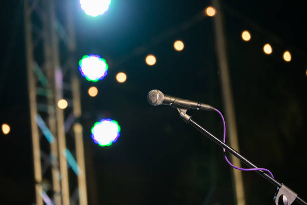 istock microphone in concert hall or conference room soft and blur style for background.Microphone over the Abstract blurred photo of conference hall or seminar room background. 1066943776