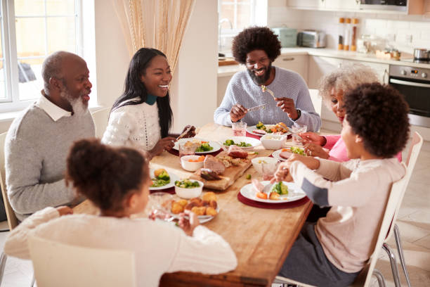 istock Multi generation mixed race family eating their Sunday dinner together at home, elevated view 1066944250