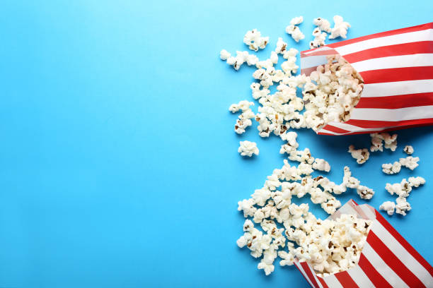 istock Popcorn in paper bags on blue background 1066946012