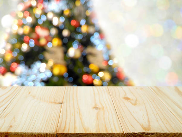 istock Blurred colorful Christmas tree background with empty wooden table 1066946428