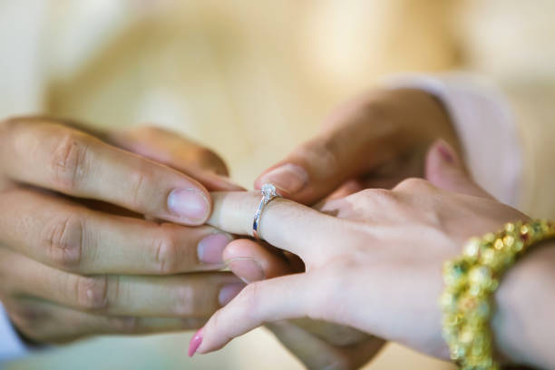 istock Wedding rings. He Put the Wedding Ring on Her. Close up Groom Put the Ring on bride. 1066946436