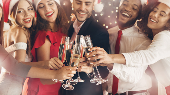 Diverse friends clinking with champagne glasses on New Year's Eve, closeup