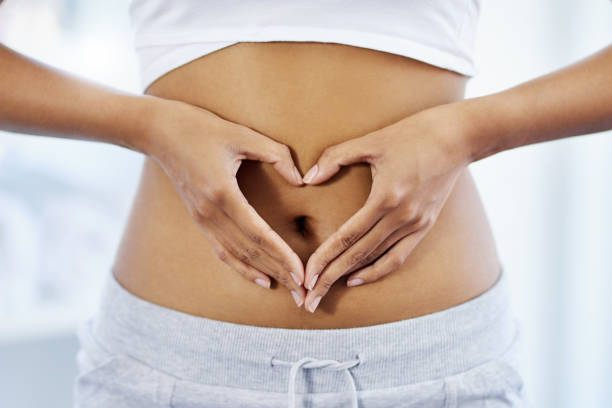 Keeping your gut in great shape is key Cropped shot of an unrecognizable woman posing with her hands on her stomach abdomen stock pictures, royalty-free photos & images