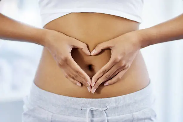 Cropped shot of an unrecognizable woman posing with her hands on her stomach